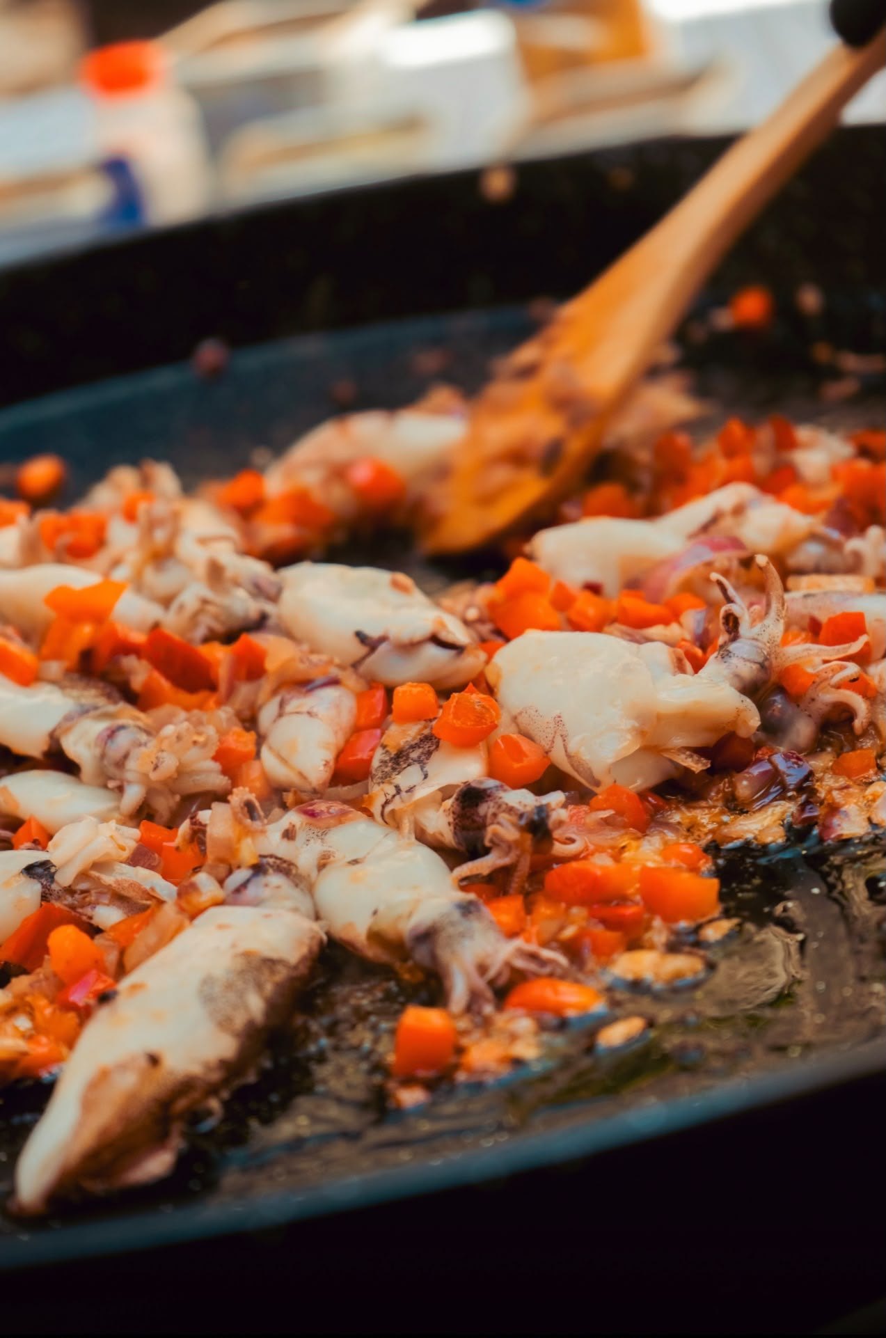 A pan of seafood rice cooking down over the fire
