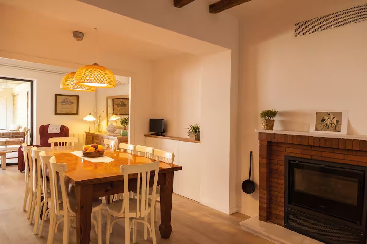 The indoor dining room with its stone fireplace and long table
