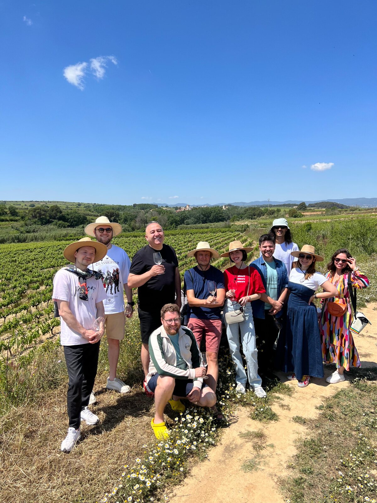 The group in straw hats among the vines